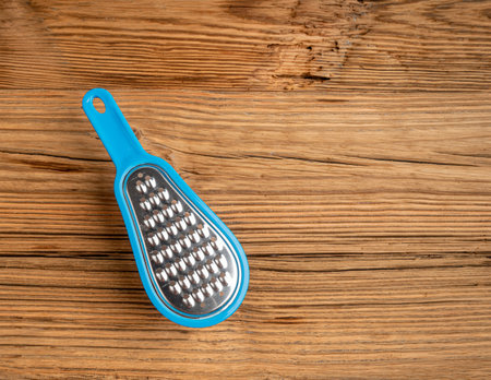 Small Grater, Mini Cheese Grater with Plastic Container on Wooden Table Backgroundの写真素材