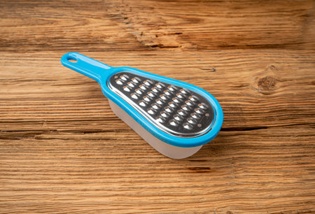 Small Grater, Mini Cheese Grater with Plastic Container on Wooden Table Backgroundの写真素材