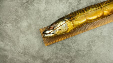 Appetizing smoked fish on kitchen board.Smoked mackerel.Smoked fish with spices