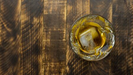 Glass of whiskey on wooden background close up, wooden tableの写真素材