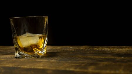 Glass of whiskey on wooden background close up, wooden tableの写真素材