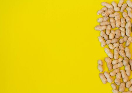 Peanuts pattern isolated on a yellow backround. Repetition concept. Top view