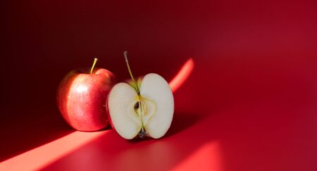 Red apples on a red background. Flat lay, top view, copy spaceの写真素材
