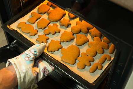 cooking gingerbread christmas cookies in the kitchen in the oven.
