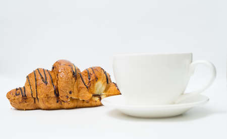 Top view or flat lay of coffee cup and croissant on white background with copy space. Morning coffee and snack.の写真素材