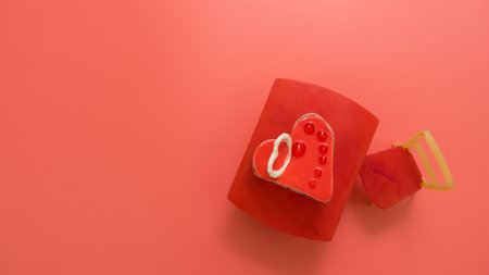 Chocolate muffin with a white chocolate heart on top, on a pink background with space for text. Cake on a toy table from chairs. Valentine's day, postcardの写真素材