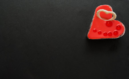 Valentine's Day concept. Red heart on a black slate background. Sweet gift. A symbol of love, happiness and devotion. View from above.の写真素材