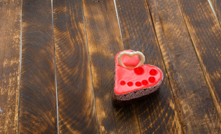 Valentine's day concept. Red heart on a wooden background. Sweet gift. A symbol of love, happiness and devotion. View from above. Copy spaceの写真素材