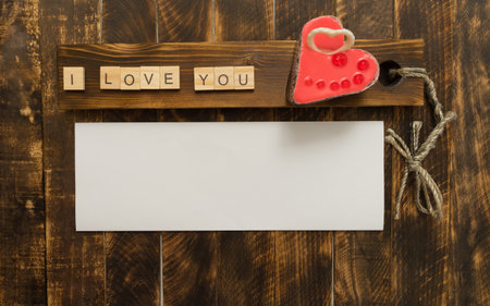 Valentine's Day heart-shaped cake on a wooden background with space for text. Words I love you from wooden tablets.の写真素材