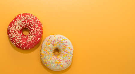 Donuts isolated on yellow background. Delicious glazed donuts close-up.の写真素材
