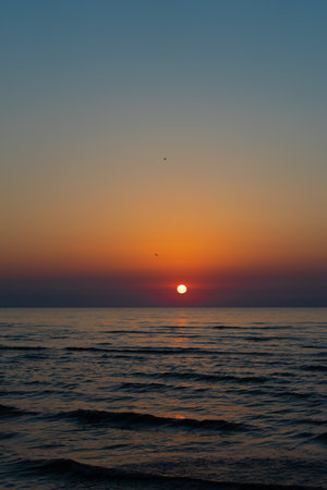 Beautiful sunset over the sea, orange sun. Vacation at the sea, bright orange dawn on the mountainzon above the seaの写真素材