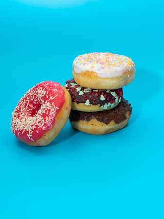 Colorful round donuts with filling on a blue background. Sweets.Flat lay, top view.の写真素材