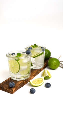 Various berry lemonade or mojito cocktails, fresh iced lemon lime blueberry infused water, summer healthy detox drinks isolated on white top viewの写真素材