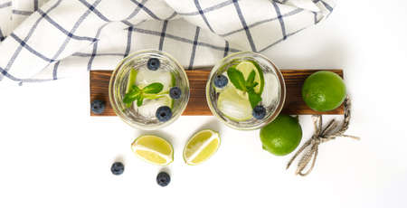 Various berry lemonade or mojito cocktails, fresh iced lemon lime blueberry infused water, summer healthy detox drinks isolated on white top viewの写真素材