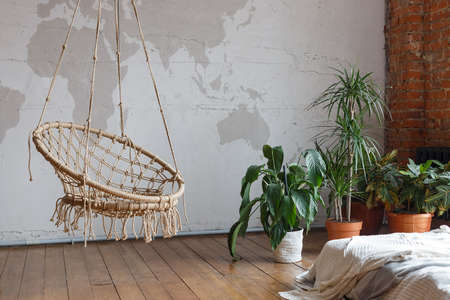 Modern comfortable bedroom interior with green houseplants and a swing, loft furnished. Unusual...