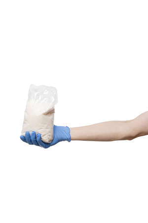 man in blue gloves holding pack of sugar. bag hold in hand isolated on whiteの写真素材