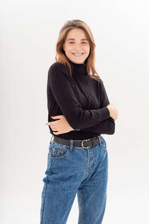 young caucasian woman in turtleneck and blue jeans isolated on white background