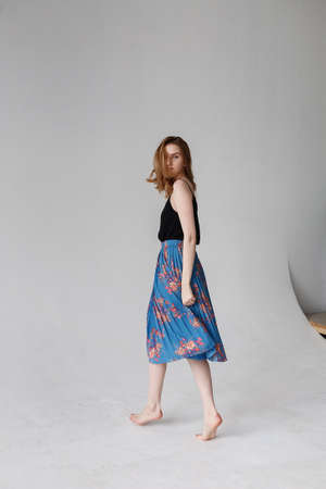 caucasian skinny pretty female with long brown hair dances on white cycloramaの写真素材