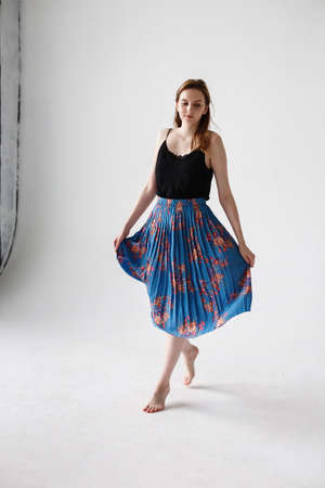 caucasian skinny pretty female with long brown hair dances on white cycloramaの写真素材