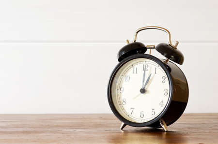 Retro alarm clock and white wooden wall backgroundの写真素材