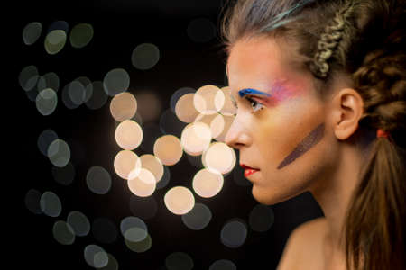 Young woman portrait, multicolor face painting. Model with make up. Girl with art paint, decorative...