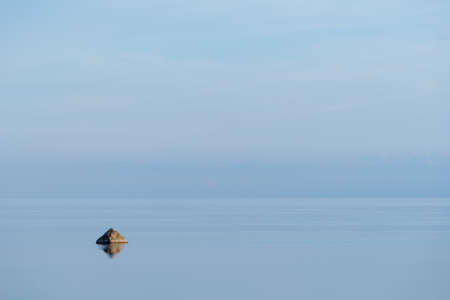 Evening sunlight on the coast, blue sky reflection on the water. Beach in summer. Seaside natural environment background. Shore in Osmussaar Island, Nature Reserve in Estonia, National Park in Europeの写真素材