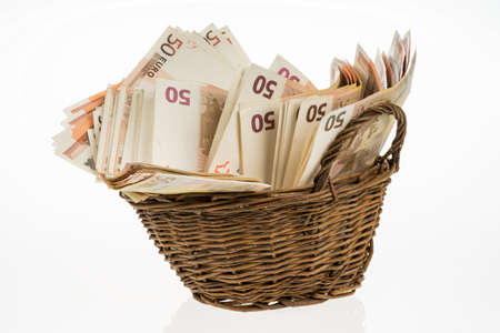 Fifty euro banknotes pile. Money bunch stack. Bill and brown basket on white background. Euros heapの写真素材
