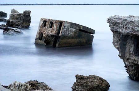 Liepaja beach bunker. Brick house, soft water, waves and rocks. Abandoned military ruins facilities...