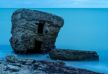 Liepaja beach bunker. Brick house, soft water, waves and rocks. Abandoned military ruins facilities in a stormy sea. Barracks building in the Baltic sea.  Liepaja, Latvia, Europe.の写真素材