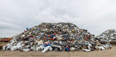 Dumping ground. Scrap metal heap. Compressed crushed cars is returned for recycling. Iron waste ground in the industrial area. Stacked automobileの写真素材