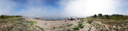 Rocky beach and morning fog in summer. White clouds, blue sky and sea, mist, coast, forest, seaside natural environment. Shore in Koipsi Island, Estonia, Europe. 360 degrees panorama.の写真素材