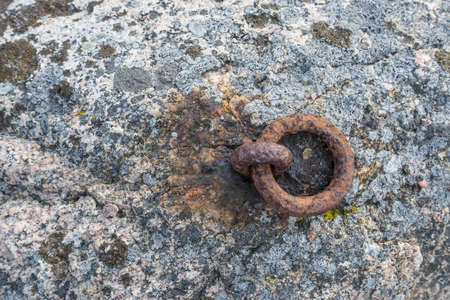 Old and rusty mooring ring for ships fixing. Dock for small boats.の写真素材