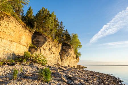 Sunset on the beach. Limestone cliff in the sea under blue sky and white clouds. Kesselaid, a small island in Estonia. Nordic countries, Europeの写真素材
