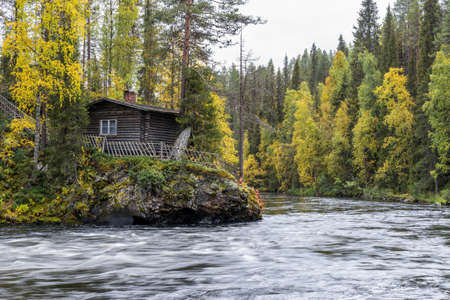Cliff, stone wall, forest, waterfall and wild river view in autumn. Fall colors - ruska time in Myllykoski. One part of Karhunkierros Trail. Oulanka National Park in north Finland. Lapland, Europeの写真素材