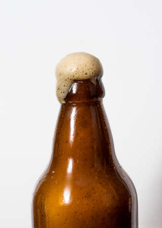 Brown glass bottle and beer, white background.の写真素材