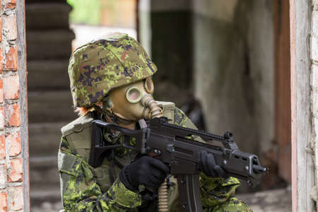 Portrait of armed woman with camouflage. Young female soldier observe with firearm. Child soldier...