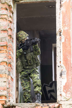 Portrait of armed woman with camouflage. Young female soldier observe with firearm. Child soldier...