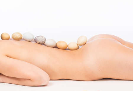 Nude woman body parts and  multicolored hand painted Easter eggs.