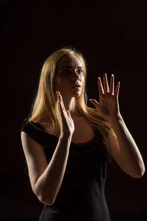 Young woman waving her hands. Blonde girl  expressing with raised hands their emotions in a studio...