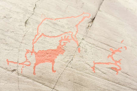 Rock art in Alta Fjord, Norway. Ancient symbols, real drawing,  texture in stone. Red ocher paint. Human preys on animals deer.  Group of petroglyphs, dating from c. 4200 to 500 B.C.のeditorial素材