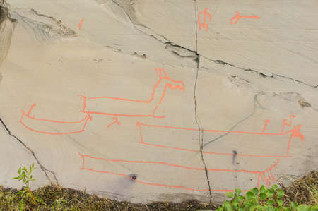 Rock art in Alta Fjord, Norway. Ancient symbols, real drawing,  texture in stone. Red ocher paint. Human preys on animals deer.  Group of petroglyphs, dating from c. 4200 to 500 B.C.のeditorial素材