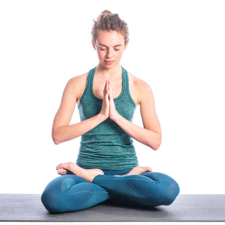 Athletic young blonde woman doing yoga practice isolated on white background. Concept of sport - healthy life and natural balance between body and spiritual developmentの写真素材