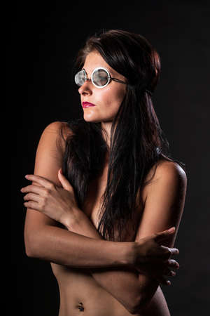Young nude woman with make up. Model with glasses. Naked girl beauty portrait on black background.の写真素材