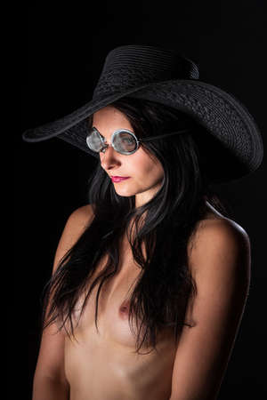 Young nude woman with make up. Model with glasses. Naked girl beauty portrait on black background.の写真素材
