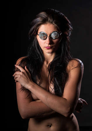 Young nude woman with make up. Model with glasses. Naked girl beauty portrait on black background.の写真素材