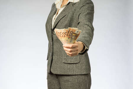 Business woman with gray jacket parses the money fan. European finance currency, fifty euro banknotesの写真素材