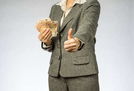 Business woman with gray jacket parses the money fan. European finance currency, fifty euro banknotesの写真素材