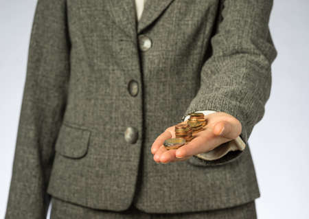Business woman holding money in hand. European finance currency, coins.の写真素材
