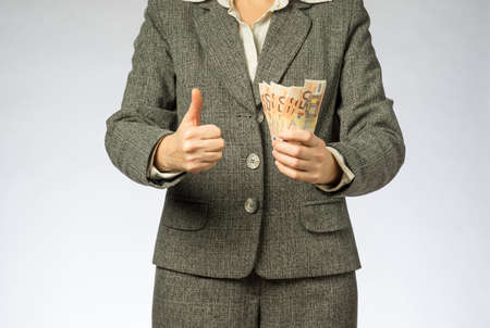 Business woman with gray jacket parses the money fan. European finance currency, fifty euro banknotesの写真素材