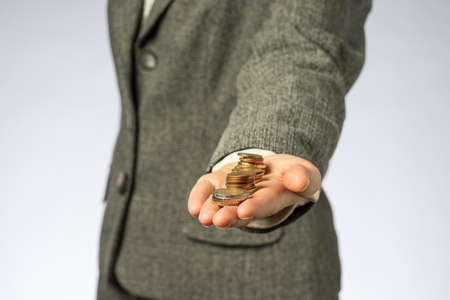 Business woman holding money in hand. European finance currency, coins.の写真素材